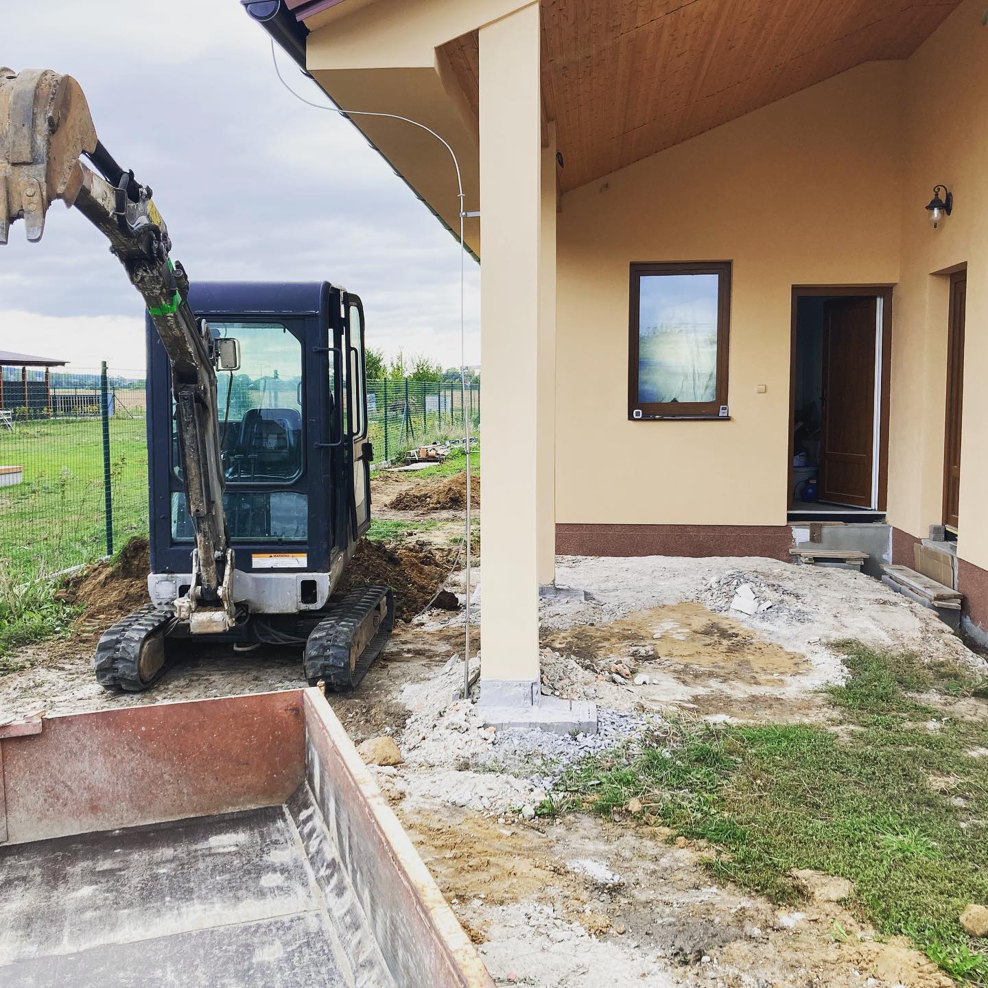 Minibagr při zemních pracích u rodinného domu